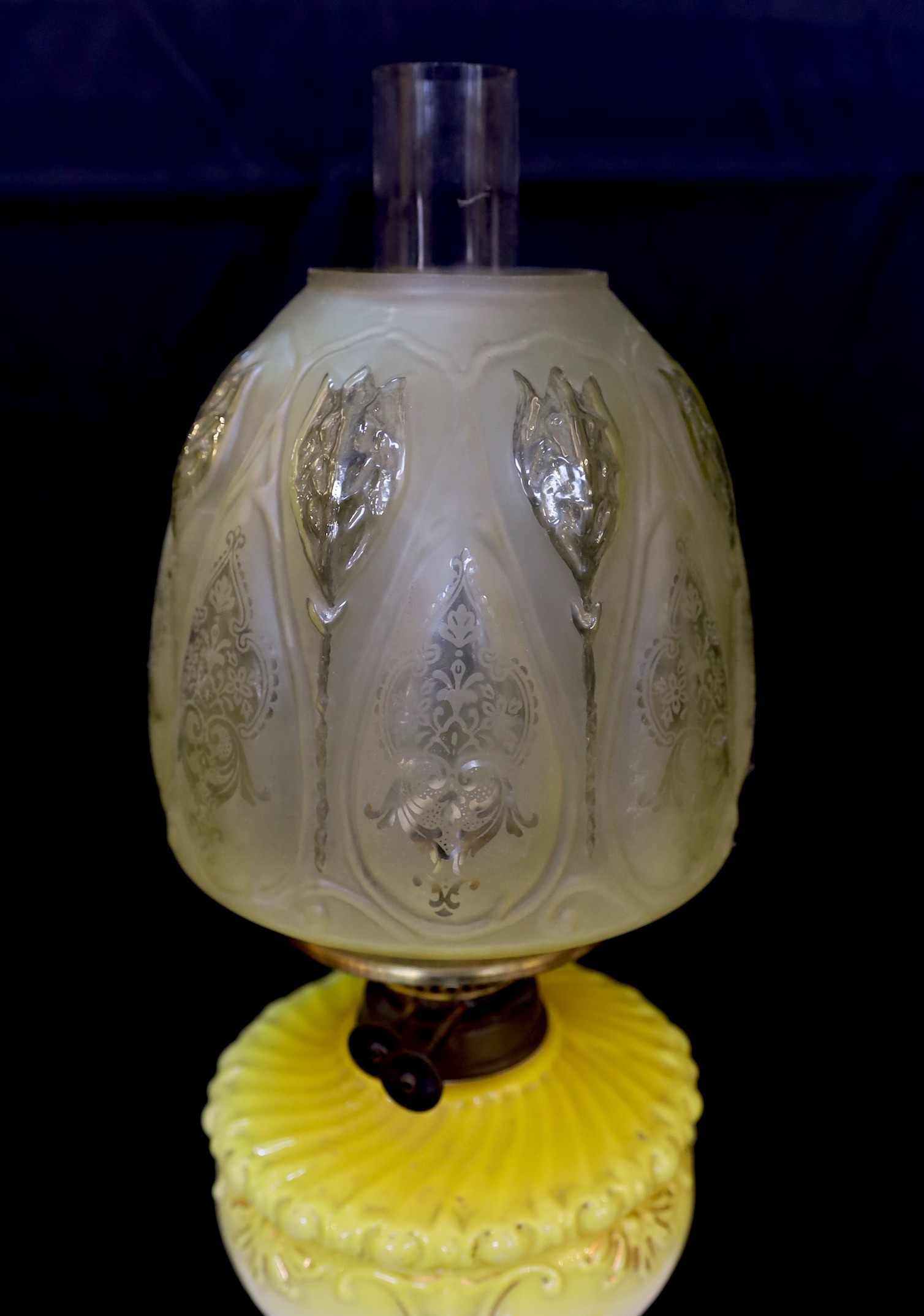 A Victorian brass oil lamp with opaque yellow glass reservoir, duplex mechanism, etched glass globe and flue, height overall 72cm